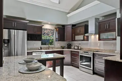 a large kitchen with wooden cabinets and granite counter tops at Best Location Pet Friendly Fenced Yard in Orlando