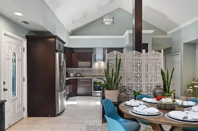 a kitchen with a table and blue chairs at Best Location Pet Friendly Fenced Yard in Orlando