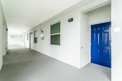 an empty hallway of a hospital with a blue door at Gorgeous 2Bd Apto Close to Disney @ Storey Lake 404 3191 in Kissimmee