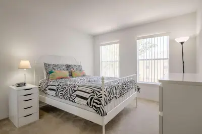 a white bedroom with a zebra print bed and windows at Club Cortile 3 Bedroom Condo Resort Pool 8 Miles to Disney in Kissimmee