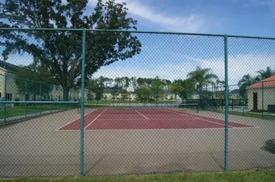 a tennis court with a net on a tennis court at Club Cortile 3 Bedroom Condo Resort Pool 8 Miles to Disney in Kissimmee