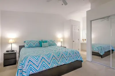 a bedroom with a bed with a blue and white comforter at Club Cortile 3 Bedroom Condo Resort Pool 8 Miles to Disney in Kissimmee