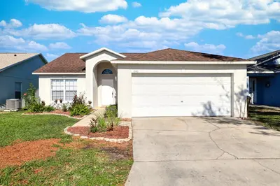 a house with a white garage at Clear Creek 3 Bedroom Home Private Pool 15 Min to Disney in Orlando