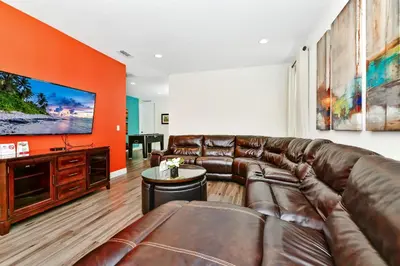 a living room with a leather couch and a flat screen tv at Spectacular Home Near Disney With Private Pool And Waterpark & Resort Access At Encore Resorts Reunion - 7523Mr in Kissimmee