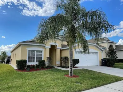 a palm tree in front of a house at Vacation Resort Home Right Outside of Disney World Parks with Private Pool home in Kissimmee