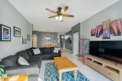 a living room with a couch and a flat screen tv at Vacation Resort Home Right Outside of Disney World Parks with Private Pool home in Kissimmee