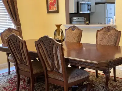 a dining room table with chairs and a kitchen at Windsor Hill Resort Home w Pool, 5 Min from Disney in Orlando