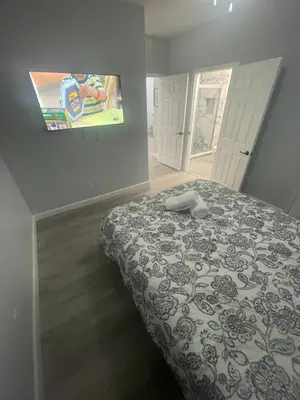 a bedroom with a bed and a tv on the wall at Home sweet Home near Disneyland in Kissimmee