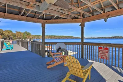 a deck with two chairs and a table and chairs on it at 1 Mi to Disney Condo with Water-View Balcony! in Orlando