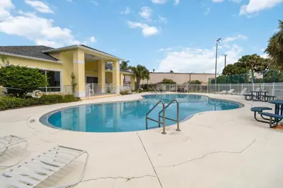 a large swimming pool with chairs and tables at Huge Screened Patio That Overlooks Lake Buck, Near Famous Attractions!! in Orlando