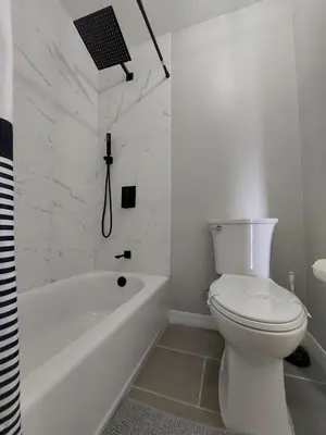 a white bathroom with a toilet and a bath tub at Amazing 32 Condo, Gated Community At Club Cortile!! in Kissimmee