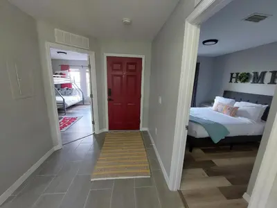 a bedroom with a red door and a bed at Amazing 32 Condo, Gated Community At Club Cortile!! in Kissimmee
