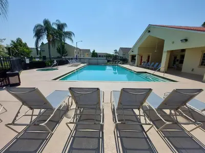 a group of chairs sitting around a swimming pool at Amazing 32 Condo, Gated Community At Club Cortile!! in Kissimmee