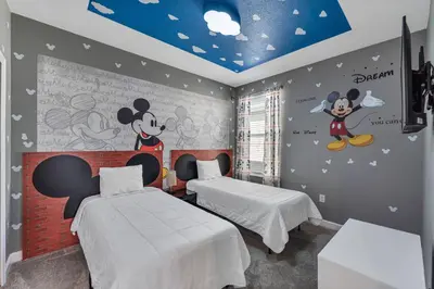 a bedroom with two beds with mickeys on the walls at Storey Lake Resort, Private Pool, And Much More!! in Kissimmee