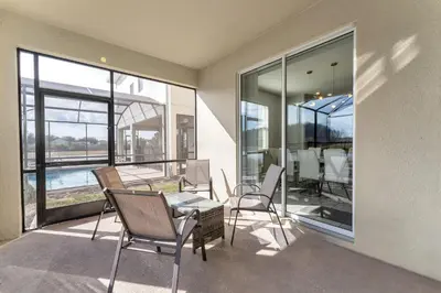 a balcony with a table and chairs and a dining room at Storey Lake Resort, Private Pool, And Much More!! in Kissimmee