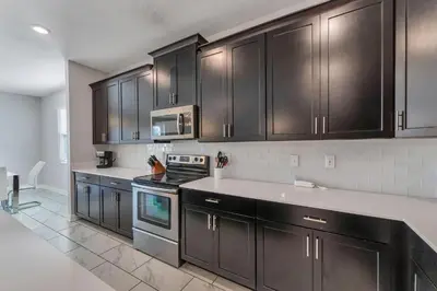 a kitchen with dark brown cabinets and appliances at Storey Lake Resort, Private Pool, And Much More!! in Kissimmee