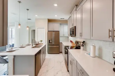 a large kitchen with white cabinets and appliances at 2751 BD -Luxury 5BR Single Family - Private Pool in Kissimmee