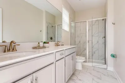 a white bathroom with a sink and a shower at 2751 BD -Luxury 5BR Single Family - Private Pool in Kissimmee