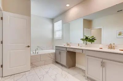 a white bathroom with a sink and a tub and a mirror at 2751 BD -Luxury 5BR Single Family - Private Pool in Kissimmee