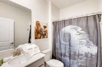 a bathroom with a toilet and a shower curtain at 2773 BD - 5Bd Home with Private Pool 14 Guests in Kissimmee