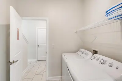 a white bathroom with a toilet and a sink at 2773 BD - 5Bd Home with Private Pool 14 Guests in Kissimmee