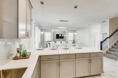 a kitchen with white cabinets and a staircase at 2859 BD - Grand Luxury Villa with a Sparkling Pool in Kissimmee