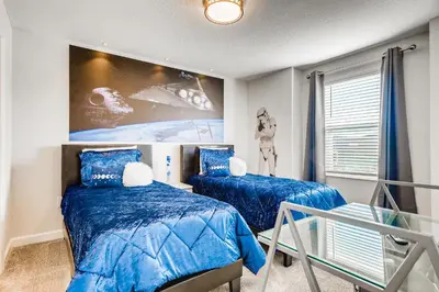 a bedroom with two beds and a large painting on the wall at 2859 BD - Grand Luxury Villa with a Sparkling Pool in Kissimmee