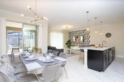 a kitchen and living room with a table and chairs at 2929 SS - Disney Delight: 4BR Pool Near Parks in Kissimmee