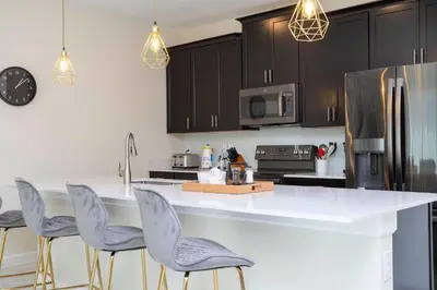 a kitchen with a white counter and chairs in it at 2929 SS - Disney Delight: 4BR Pool Near Parks in Kissimmee