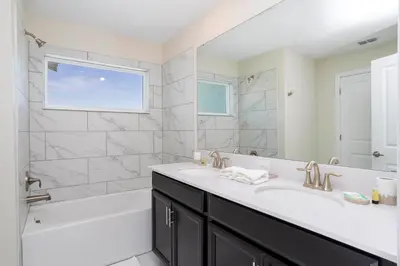 a bathroom with a sink and a tub and a shower at 2929 SS - Disney Delight: 4BR Pool Near Parks in Kissimmee