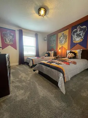 a bedroom with two beds and a television in it at 4321 QS - Magical Haven Townhome w Pool in Kissimmee