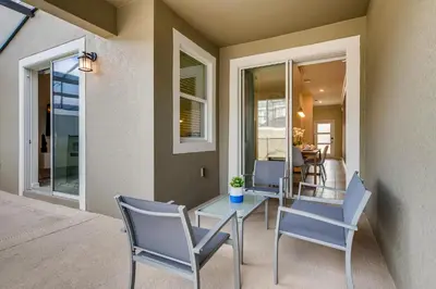 a dining room with a glass table and chairs at 4321 QS - Magical Haven Townhome w Pool in Kissimmee