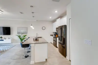 a kitchen with white cabinets and a counter top at 4321 QS - Magical Haven Townhome w Pool in Kissimmee