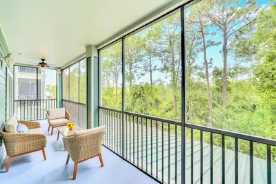 a screened in porch with two chairs and windows at 2BR Condo with Pool - Near Disney in Orlando