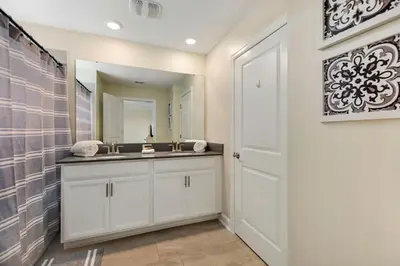 a bathroom with a sink and a mirror at Barefoot Breeze - Storey Lake By Shine Villas #833 in Kissimmee