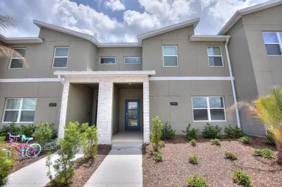 a house with a bike parked in front of it at Barefoot Breeze - Storey Lake By Shine Villas #833 in Kissimmee