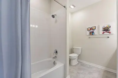 a white bathroom with a tub and a toilet at Blue Toucan At Storey Lake By Shine Villas #402 in Kissimmee