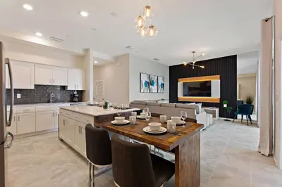 a kitchen and living room with a table and chairs at Blue Toucan At Storey Lake By Shine Villas #402 in Kissimmee