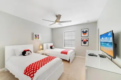 a bedroom with two beds and a flat screen tv at Star Hideaway At Storey Lake By Shine Villas #716 in Kissimmee