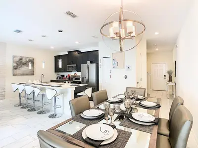 a dining room and kitchen with a table and chairs at Happy Haven At Storey Lake Resort By Shine Villas #409 in Kissimmee