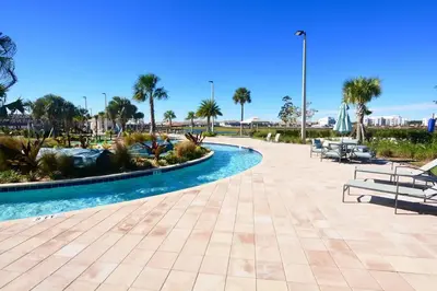 a pool at a resort with benches and palm trees at Tranquility At Storey Lake By Shine Villas #828 in Kissimmee