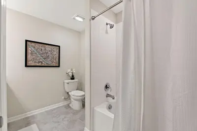a white bathroom with a toilet and a shower at Tranquility At Storey Lake By Shine Villas #828 in Kissimmee