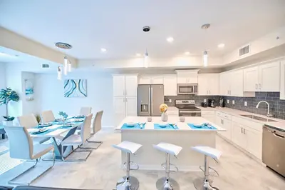 a kitchen with white cabinets and a table and chairs at Vacation Meadows - Storey Lake By Shine Villas #710 in Kissimmee