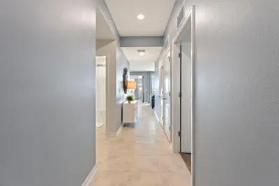 a hallway with white walls and a long hallway at Decadent Penguin - Storey Lake By Shine Villas #704 in Kissimmee