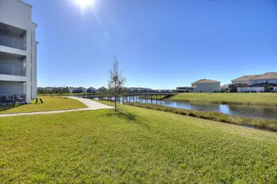 a walkway next to a river next to a building at Decadent Penguin - Storey Lake By Shine Villas #704 in Kissimmee