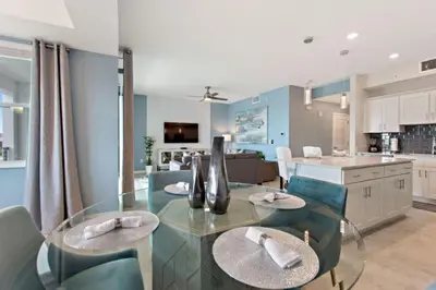 a dining room and kitchen with a glass table and chairs at Decadent Penguin - Storey Lake By Shine Villas #704 in Kissimmee