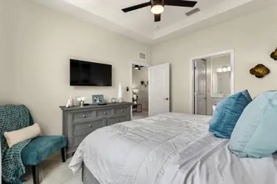 a bedroom with a bed and a tv and a chair at Lake View At Storey Lake By Shine Villas #703 in Kissimmee