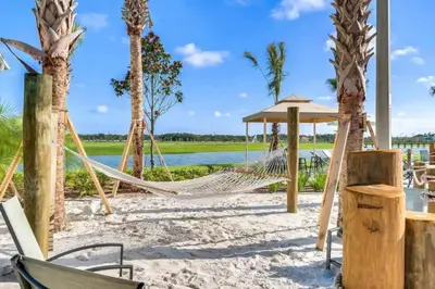 a hammock on a beach with palm trees at Lake View At Storey Lake By Shine Villas #703 in Kissimmee