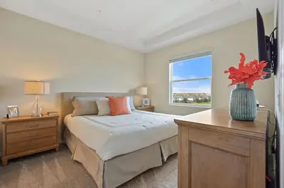 a bedroom with a bed and a vase of flowers on a table at Firecracker View Storey Lake By Shine Villas #838 in Kissimmee