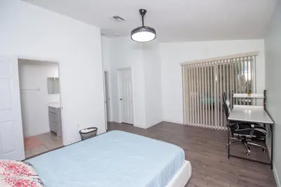 a white room with a bed and a desk at Gorgeous Fully Furnished 2-Bedroom Luxury Villa in Kissimmee